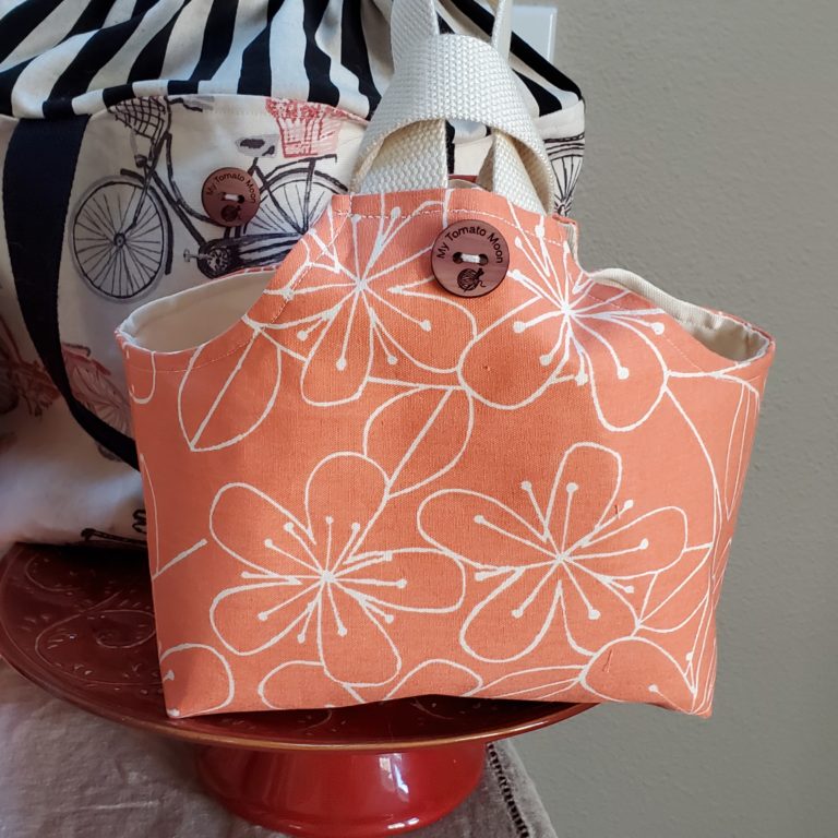 io tote in a salmon colored floral fabric