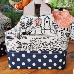 io tote with Alice in Wonderland canvas and a navy blue polka dot base