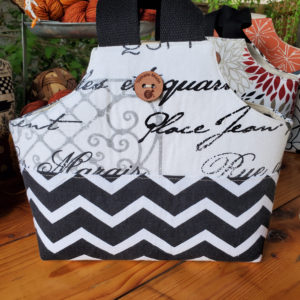 io tote with a black and white zig zag bottom and a French themed upper